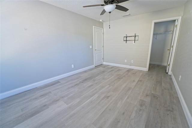 unfurnished bedroom with light wood-type flooring, baseboards, a textured ceiling, visible vents, and a closet