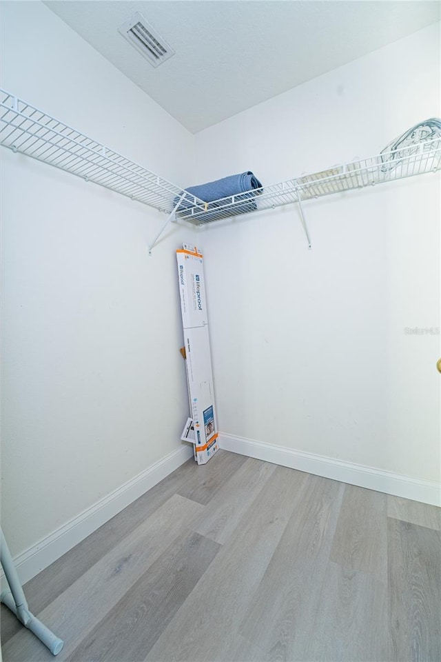 walk in closet featuring light wood-style flooring and visible vents