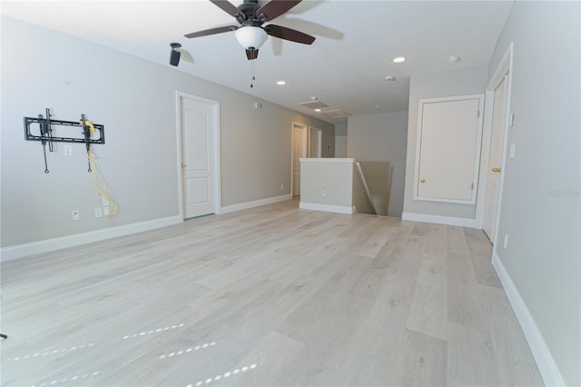 unfurnished living room with a ceiling fan, baseboards, and light wood-style floors