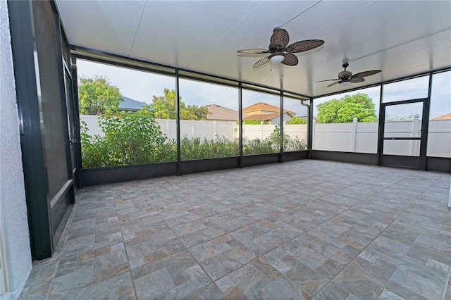 unfurnished sunroom with a ceiling fan