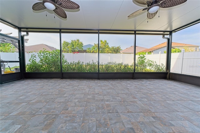 unfurnished sunroom featuring plenty of natural light and ceiling fan