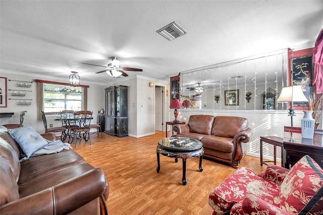 10035 Cherry Creek Ln, Port Richey, FL 34668 - living room featuring wood finished floors, visible vents, ornamental molding, ceiling fan, and a textured ceiling