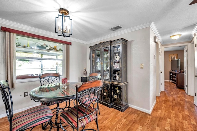 10035 Cherry Creek Ln, Port Richey, FL 34668 - dining space featuring visible vents, baseboards, light wood-type flooring, ornamental molding, and a textured ceiling