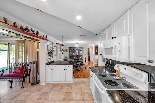 10035 Cherry Creek Ln, Port Richey, FL 34668 - kitchen with white appliances, a peninsula, white cabinets, crown molding, and backsplash