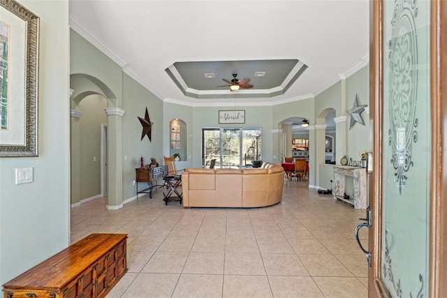 16340 Marquis Rd, Brooksville, FL 34614 - living room featuring light tile patterned floors, ornate columns, a tray ceiling, arched walkways, and ceiling fan