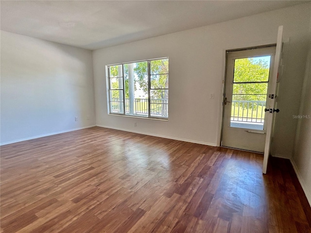unfurnished room featuring baseboards and wood finished floors