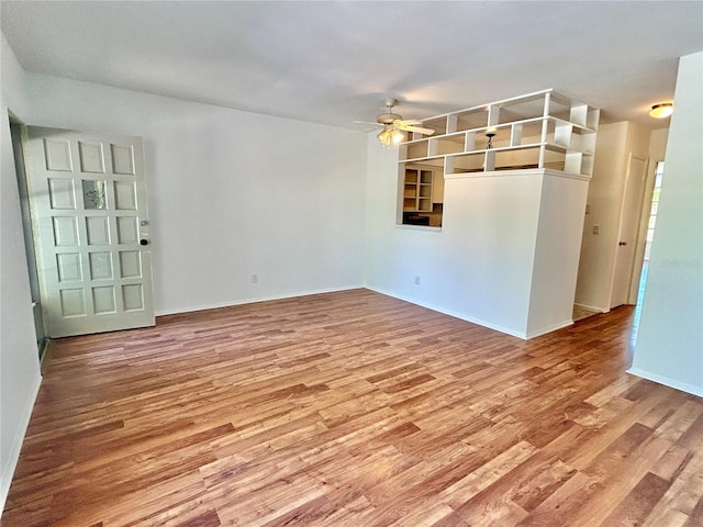 spare room featuring baseboards, ceiling fan, and wood finished floors