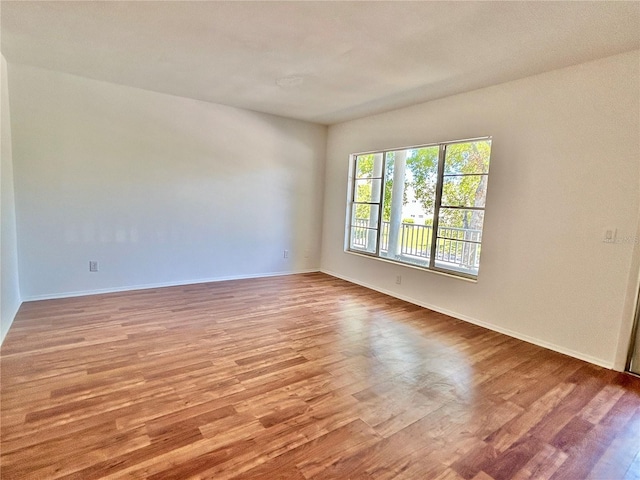 spare room featuring wood finished floors and baseboards