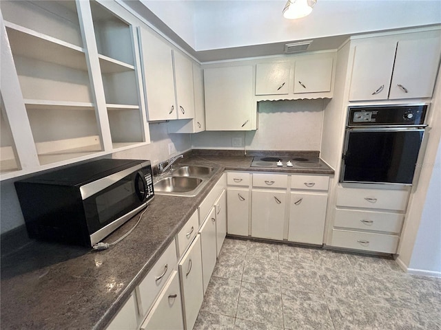 kitchen featuring dark countertops, visible vents, black appliances, white cabinetry, and a sink