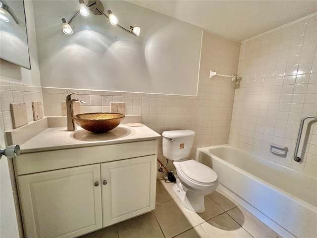 full bath featuring tile patterned floors, toilet, tile walls, washtub / shower combination, and vanity