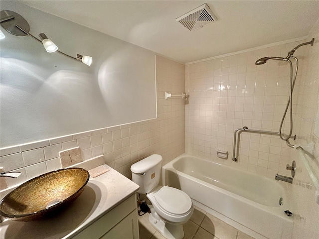 full bathroom featuring tile patterned flooring, visible vents, toilet, vanity, and tile walls