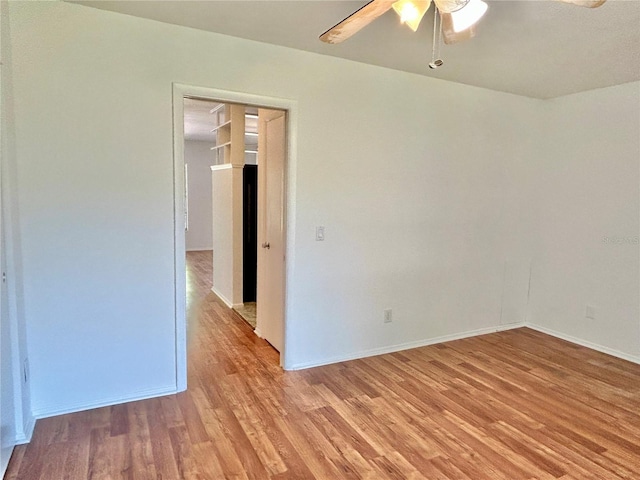 unfurnished room featuring baseboards, light wood finished floors, and ceiling fan