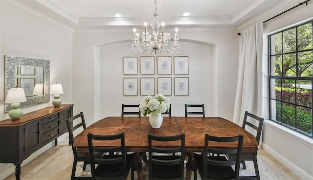 dining area featuring a notable chandelier, baseboards, and ornamental molding