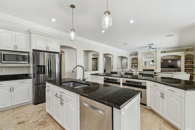 kitchen featuring a center island with sink, a sink, ornamental molding, stainless steel appliances, and open floor plan