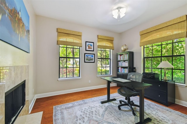 office space featuring plenty of natural light, wood finished floors, and baseboards