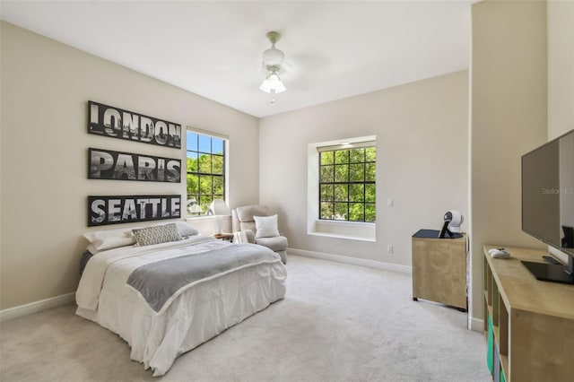 bedroom featuring baseboards, light carpet, and ceiling fan