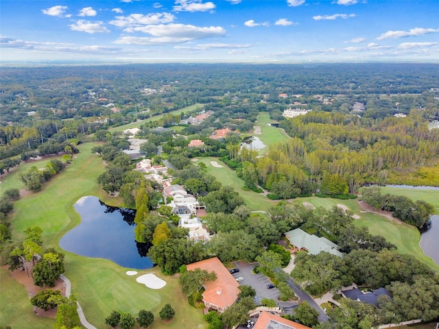 birds eye view of property with golf course view, a forest view, and a water view