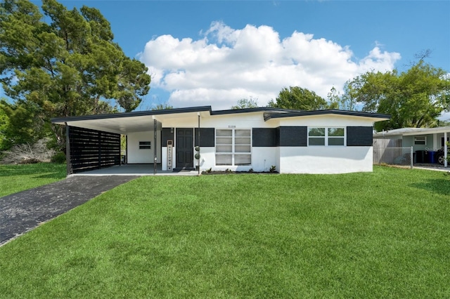 5108 Tangelo Dr, New Port Richey, FL 34652 - view of front facade with an attached carport, stucco siding, a front yard, and aphalt driveway