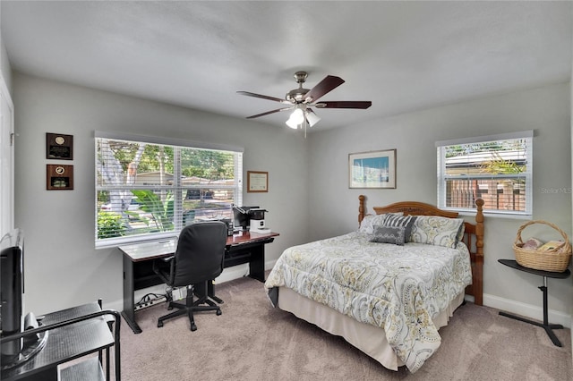 carpeted bedroom featuring baseboards, a ceiling fan, and multiple windows
