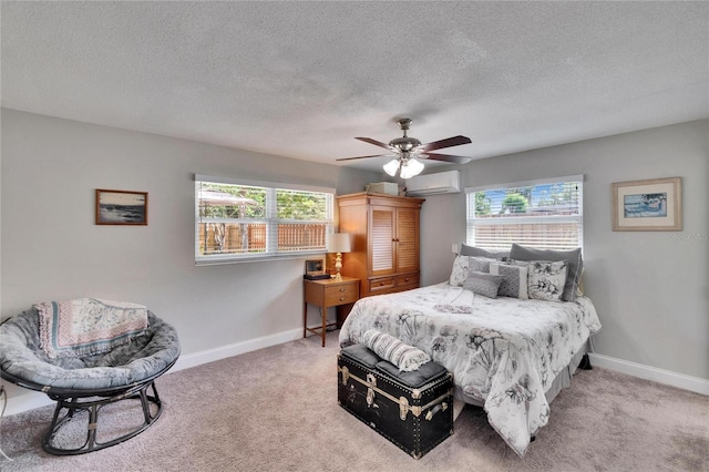 carpeted bedroom featuring a textured ceiling, a wall mounted air conditioner, baseboards, and multiple windows