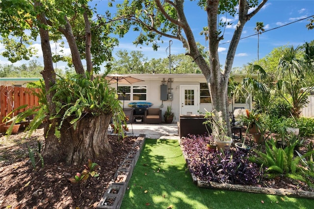 rear view of property featuring a patio, fence, and stucco siding