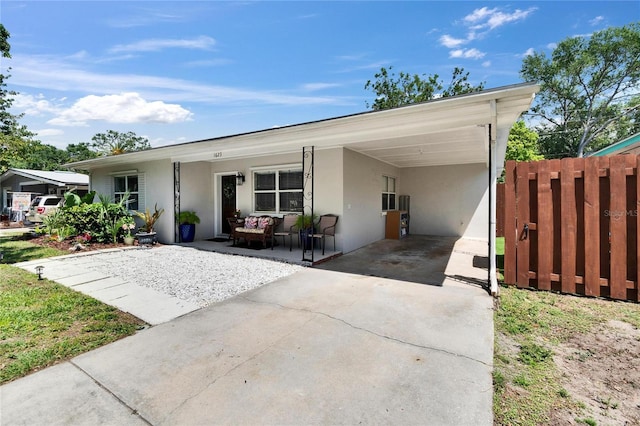 single story home with driveway, fence, an attached carport, and stucco siding