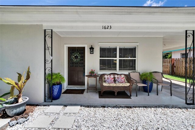 entrance to property with fence and stucco siding