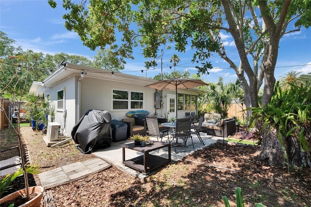 rear view of house featuring an outdoor hangout area, fence, stucco siding, and a patio area