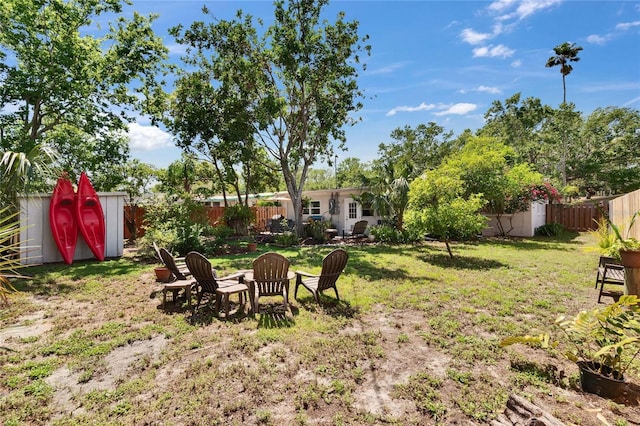 view of yard featuring an outdoor structure, a shed, and a fenced backyard
