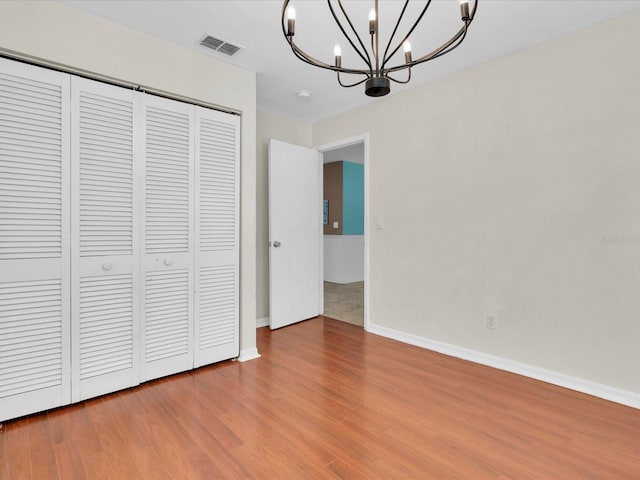 4500 23rd Ave S, Saint Petersburg, FL 33711 - unfurnished bedroom featuring baseboards, visible vents, a notable chandelier, wood finished floors, and a closet