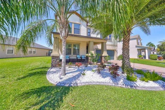 back of property with covered porch, a lawn, stucco siding, a garage, and driveway