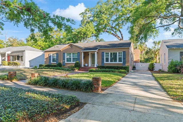 2931 W Coachman Ave, Tampa, FL 33611 - view of front of property with a gate, fence, driveway, stucco siding, and a front lawn
