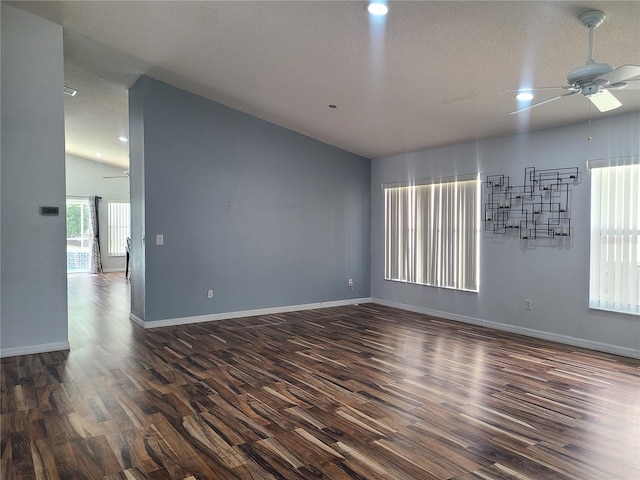 spare room featuring a ceiling fan, dark wood finished floors, and vaulted ceiling