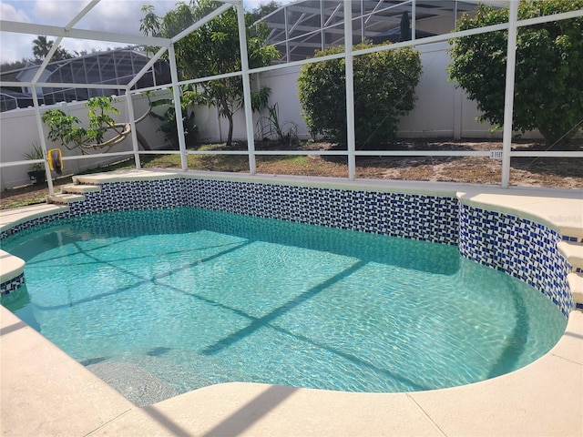 outdoor pool with a lanai and fence