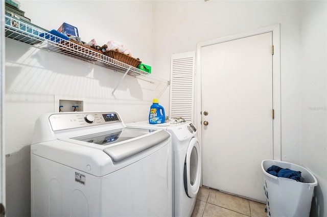 laundry area featuring washing machine and clothes dryer and light tile patterned floors