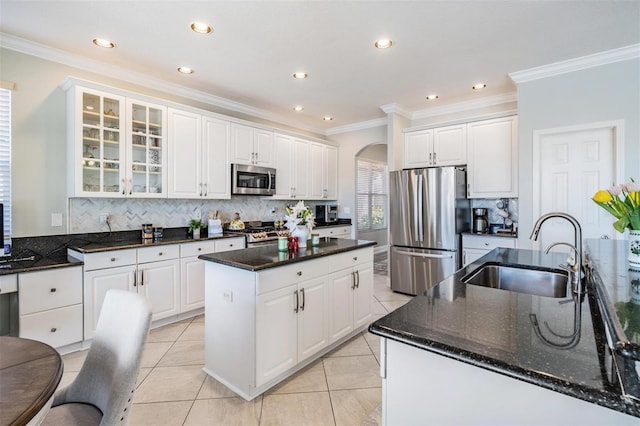 17927 Bahama Isle Cir, Tampa, FL 33647 - kitchen featuring arched walkways, stainless steel appliances, ornamental molding, a sink, and a center island