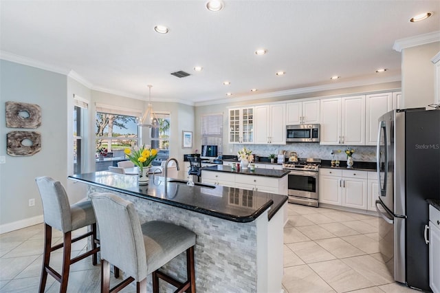 17927 Bahama Isle Cir, Tampa, FL 33647 - kitchen featuring stainless steel appliances, a kitchen bar, visible vents, white cabinetry, and an island with sink