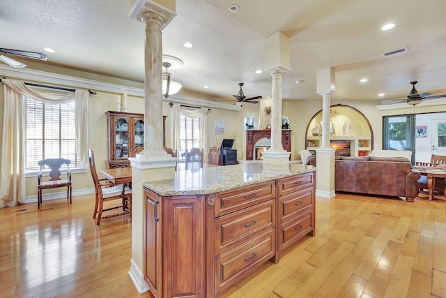 kitchen featuring a ceiling fan, decorative columns, open floor plan, light wood finished floors, and recessed lighting