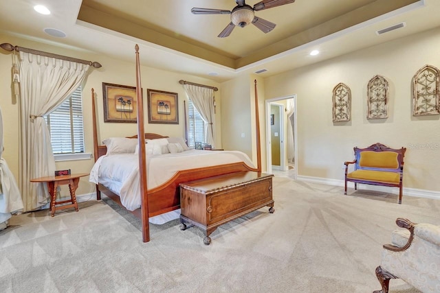 bedroom featuring carpet floors, multiple windows, recessed lighting, a tray ceiling, and baseboards