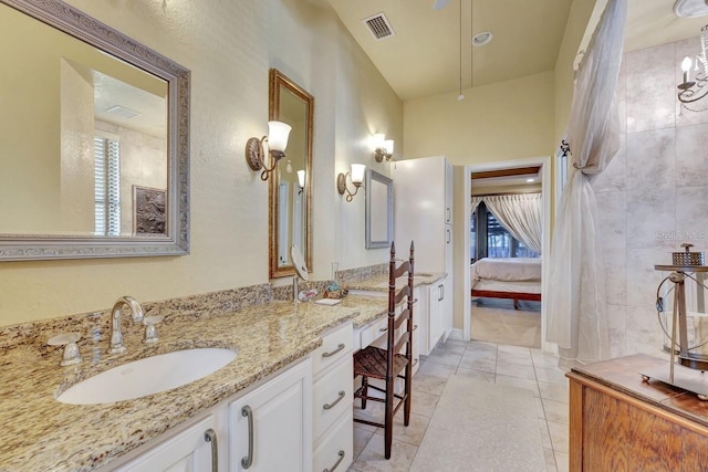 ensuite bathroom featuring vanity, plenty of natural light, and tile patterned flooring