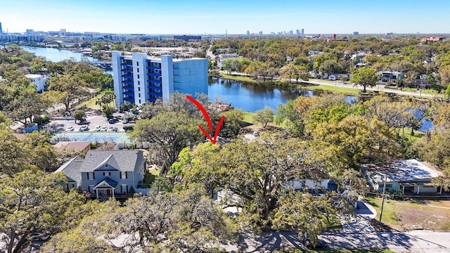 view of urban area featuring a large body of water and a tree filled landscape