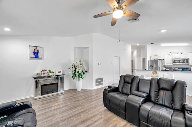 8528 Quarter Horse Dr, Riverview, FL 33578 - living room featuring ceiling fan, light wood finished floors, recessed lighting, and a glass covered fireplace