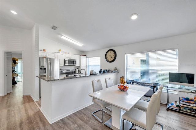 8528 Quarter Horse Dr, Riverview, FL 33578 - dining room featuring vaulted ceiling, light wood-style flooring, and recessed lighting
