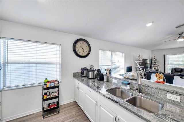 8528 Quarter Horse Dr, Riverview, FL 33578 - kitchen featuring light wood-style floors, white cabinets, open floor plan, ceiling fan, and light stone countertops