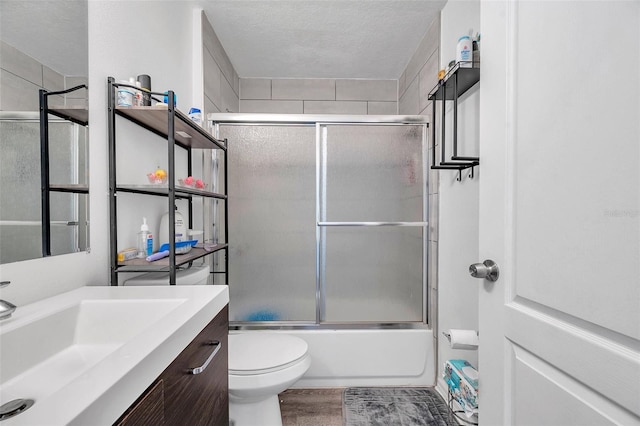 8528 Quarter Horse Dr, Riverview, FL 33578 - bathroom featuring vanity, combined bath / shower with glass door, a textured ceiling, and wood finished floors