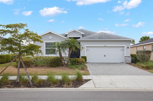 17541 Timberline Pkwy, Punta Gorda, FL 33982 - ranch-style house with stucco siding, a garage, and decorative driveway
