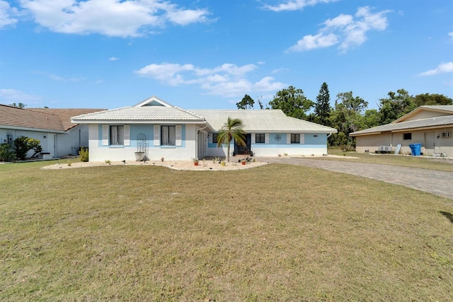 single story home featuring driveway, a front lawn, and a tile roof
