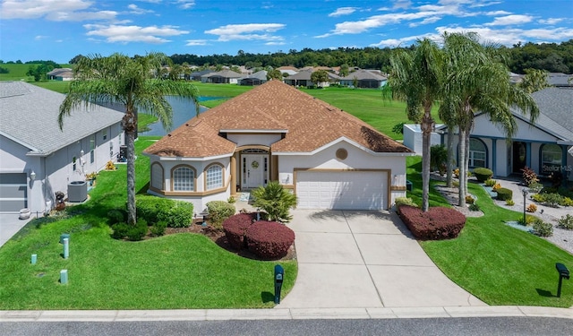 mediterranean / spanish-style home with stucco siding, a residential view, concrete driveway, a garage, and central AC unit