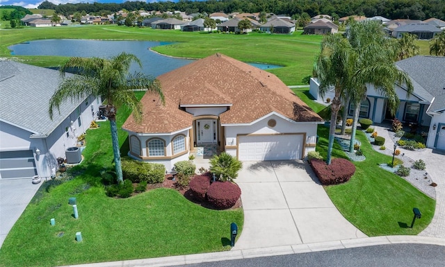 view of front of house featuring stucco siding, a water view, driveway, a residential view, and a garage