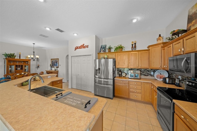 kitchen featuring visible vents, appliances with stainless steel finishes, decorative backsplash, and a sink